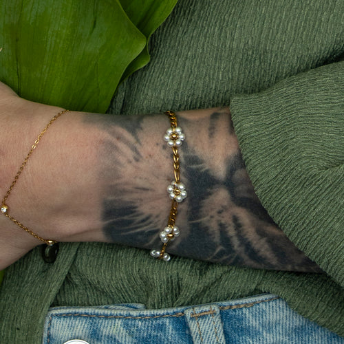Camilla Armband in gold mit feiner Gliederkette und kleinen Blumen aus weissen Kunststoffperlen.