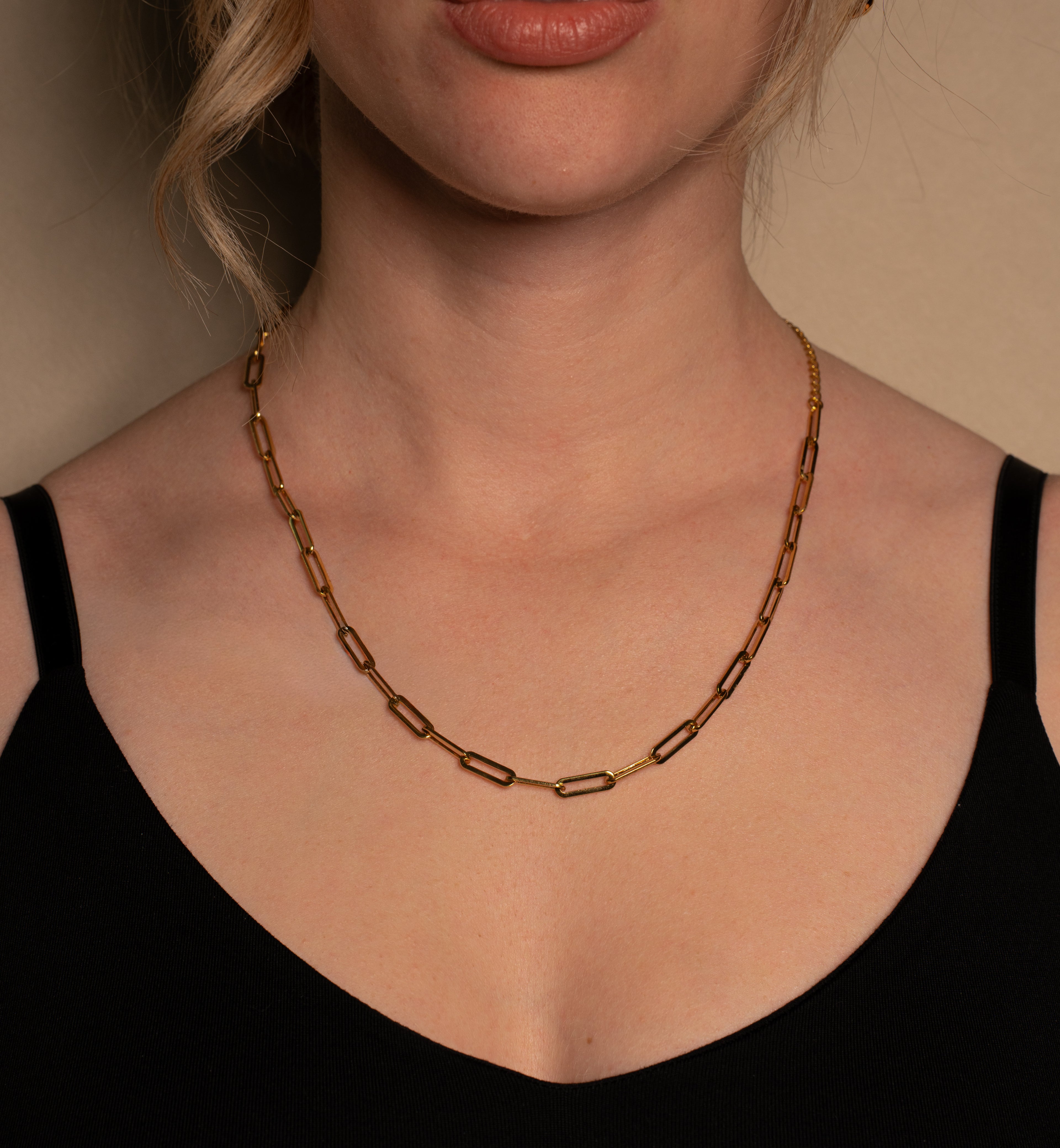 Ina Halskette in gold mit rechteckigen Gliedern, getragen von einer Frau.