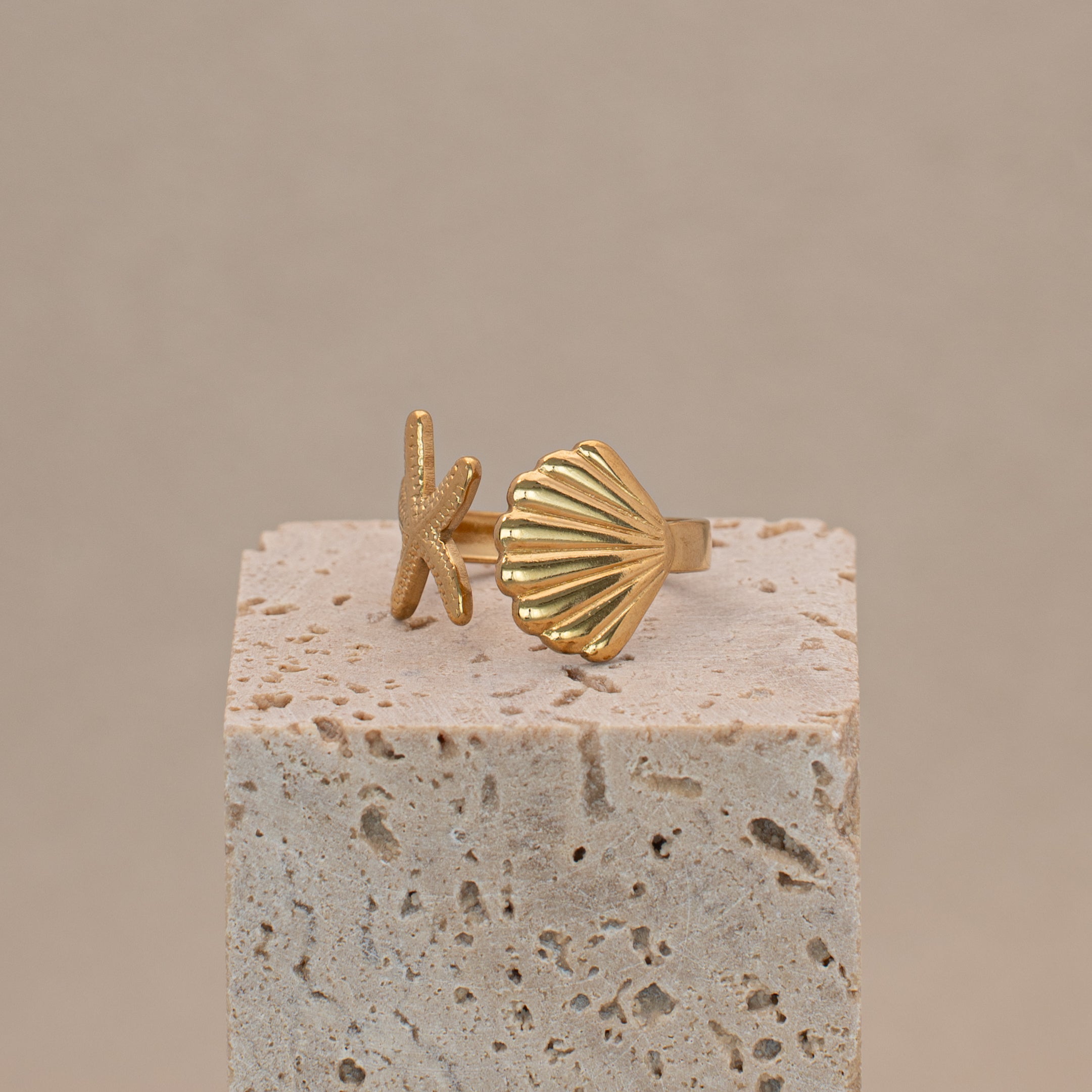 Merida Ring in Gold mit einer Muschel und einem Seestern.