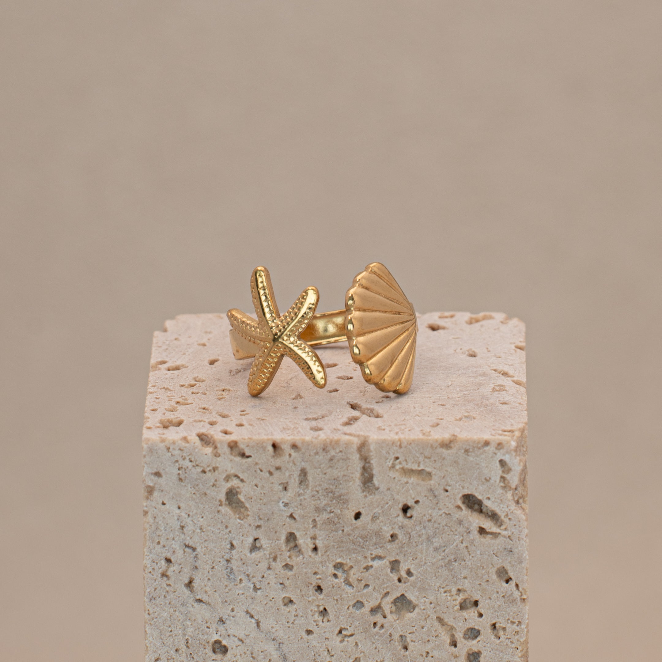 Merida Ring in Gold mit einer Muschel und einem Seestern.
