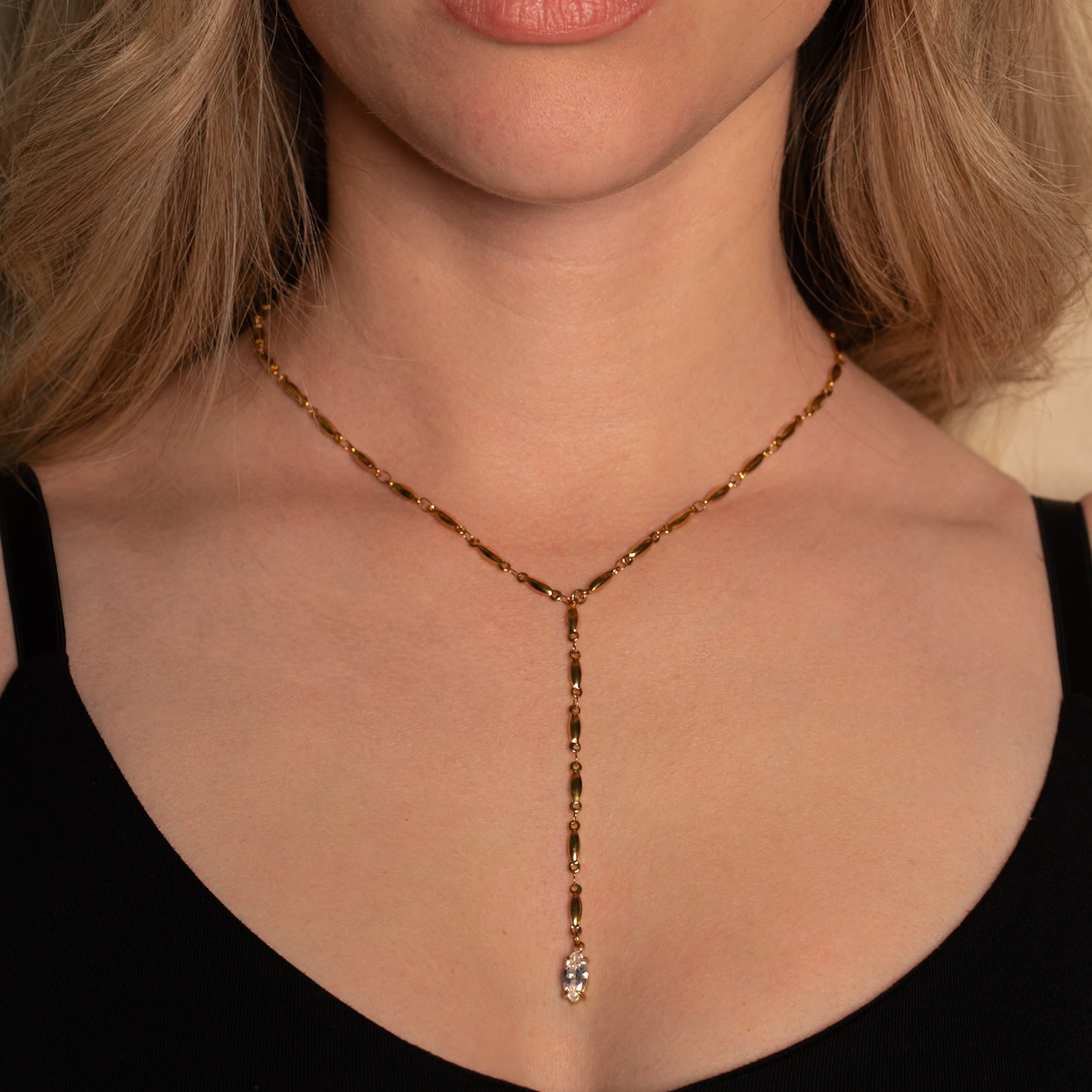 Frau trägt die Mica Halskette in gold mit Y-Form und einem Marquise-förmigen Steinanhänger.