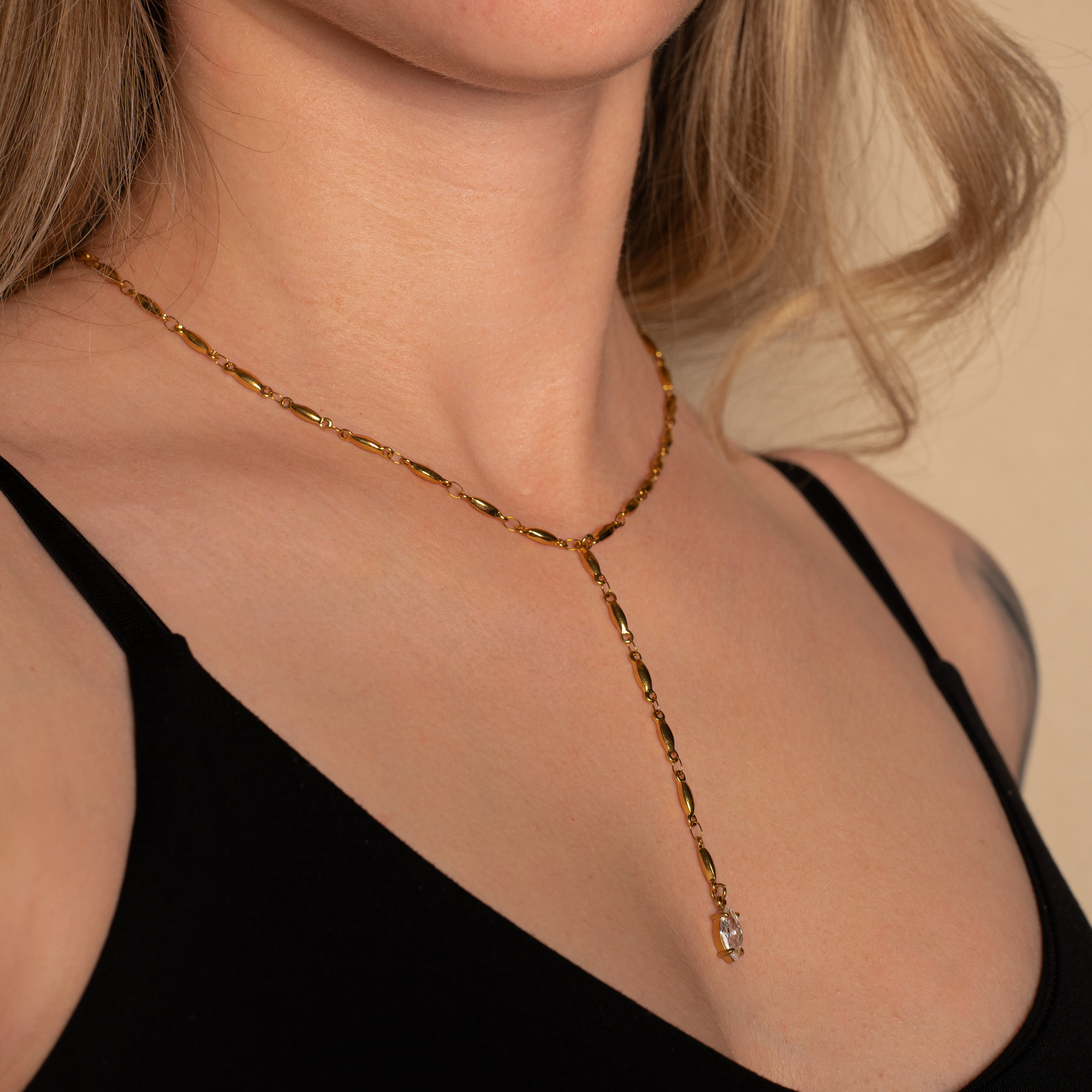 Frau trägt die Mica Halskette in gold mit Y-Form und einem Marquise-förmigen Steinanhänger.