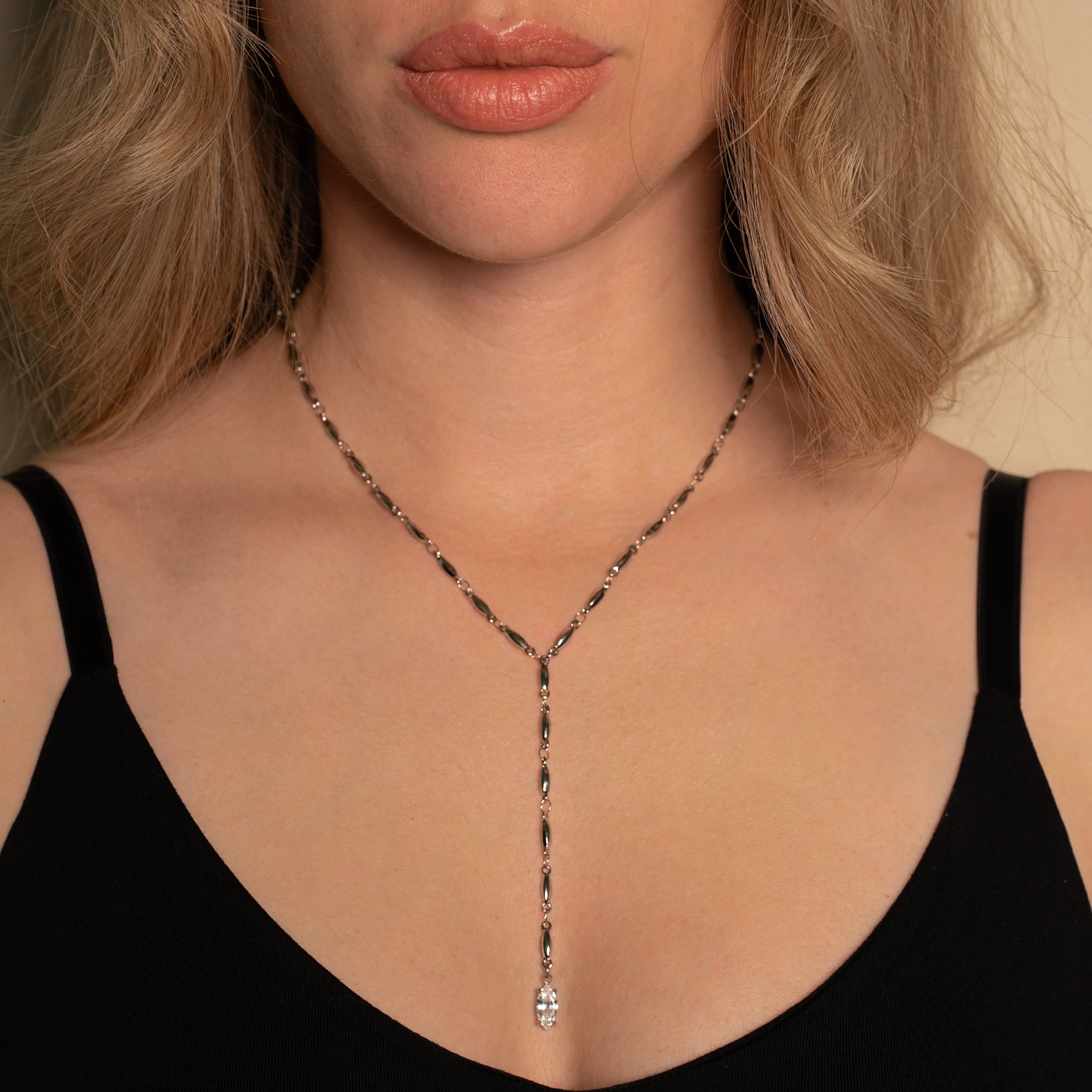 Frau trägt die Mica Halskette in silber mit Y-Form und einem Marquise-förmigen Steinanhänger.