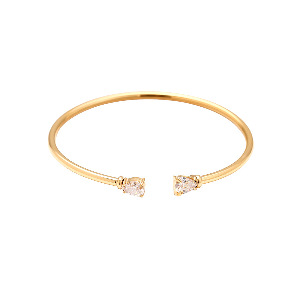 Nyx Armreif in gold aus filigranem Reifen mit zwei tropfenförmigen Steinen an den Enden.