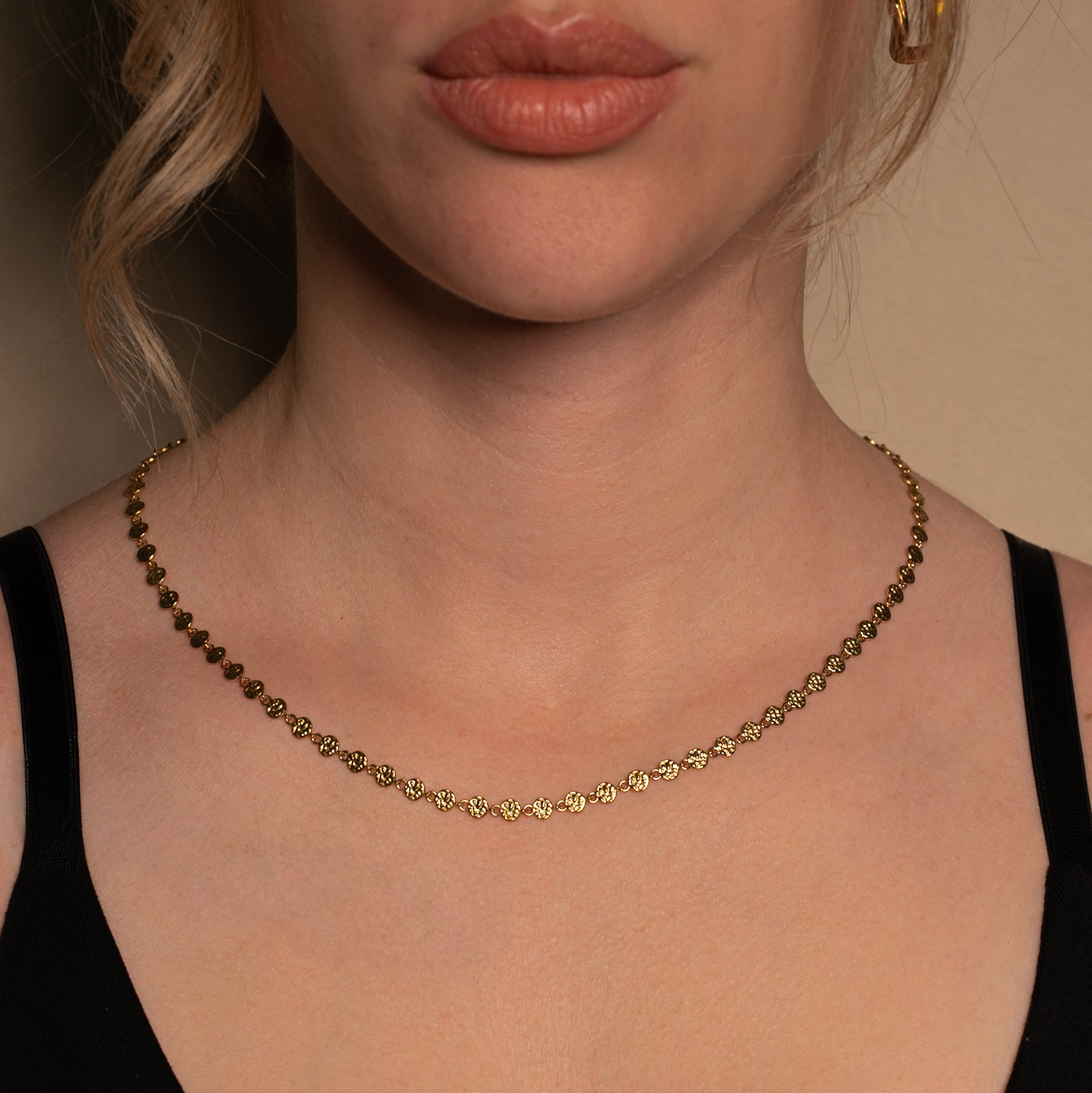 Frau trägt die Rumi Halskette in gold bestehend aus einer Kette mit kleinen unregelmässigen Scheiben.