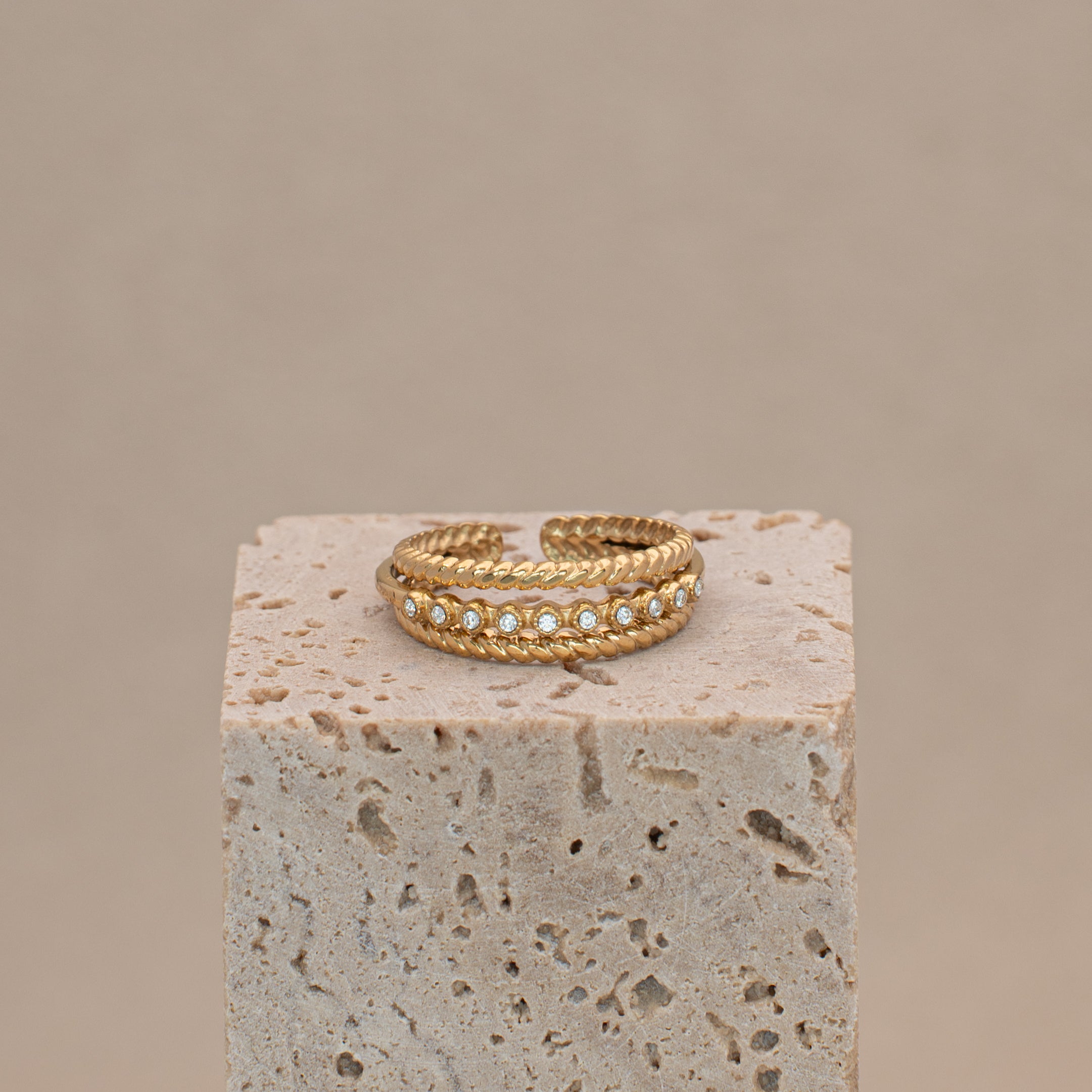 Sari Ring in gold mit drei Reihen und der mittleren Reihe mit Steinen besetzt.