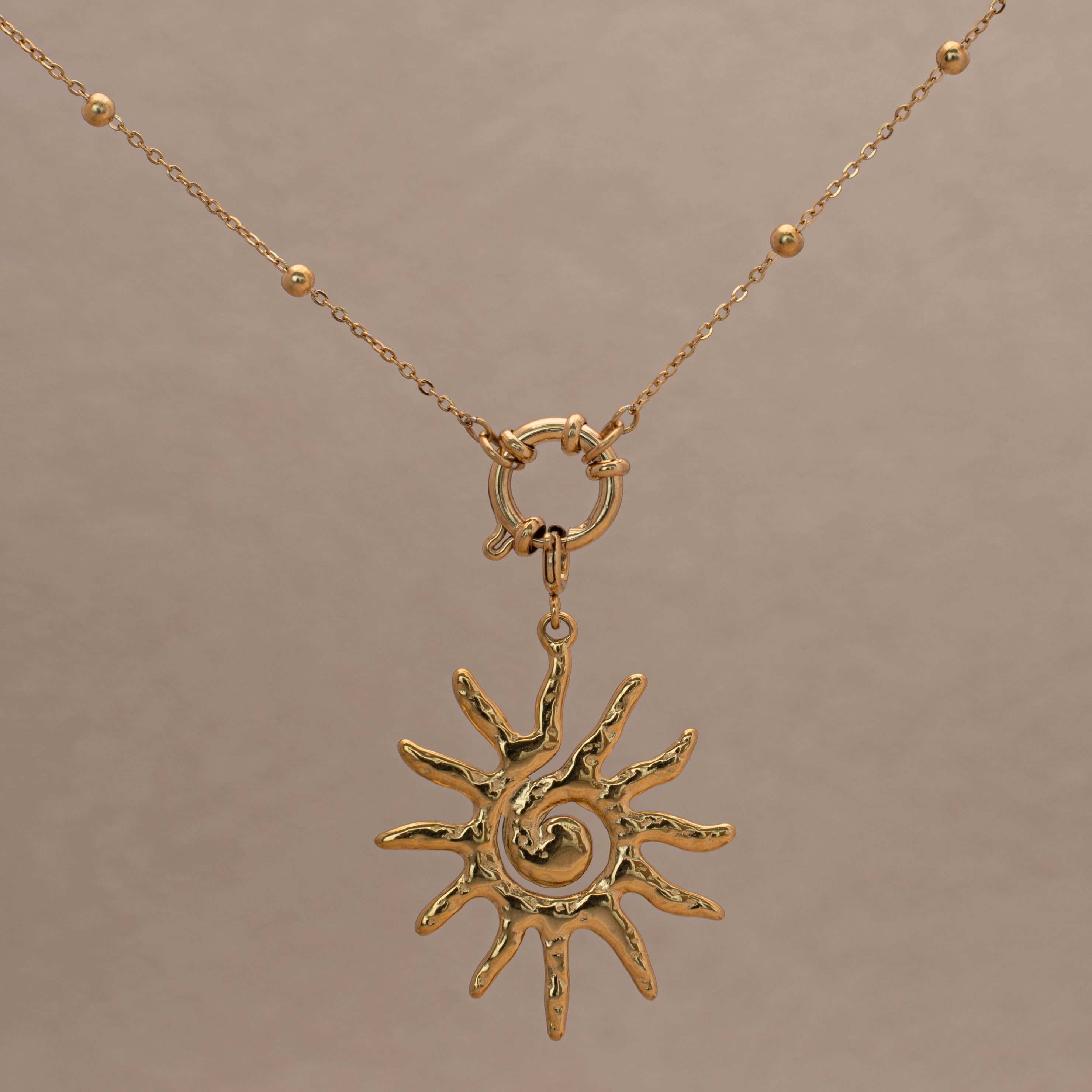 Sol Halskette in gold mit Kugeln und einem Sonnen-Anhänger.