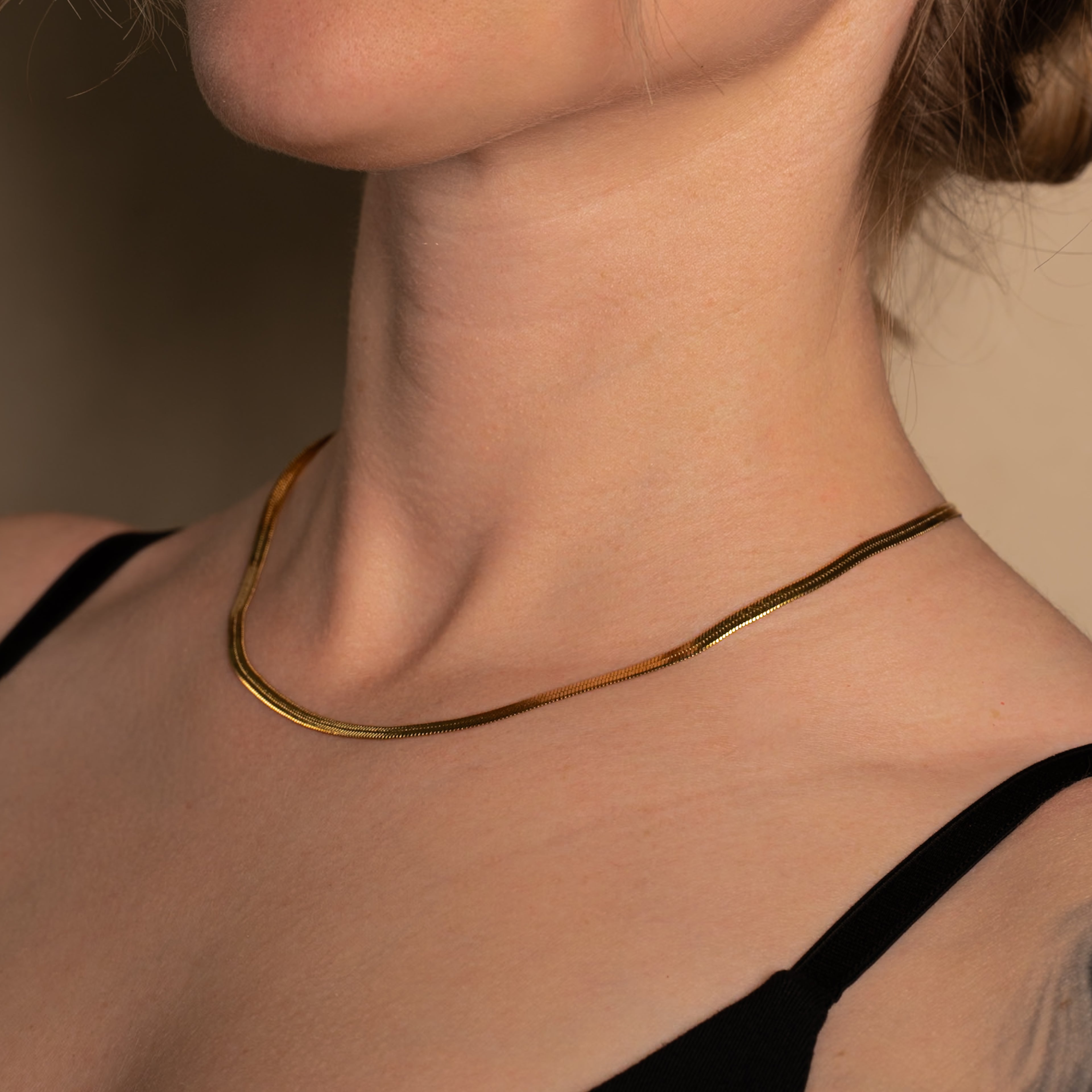 Frau trägt die Velvet Halskette in gold, simple Schlangenkette.
